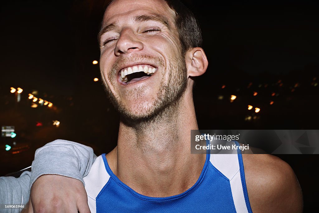 Young man smiling, at night