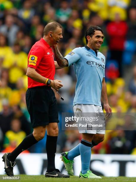 Carlos Tevez of Manchester City shares a moment with referee Mark Halsey as he is substituted during the Barclays Premier League match between...