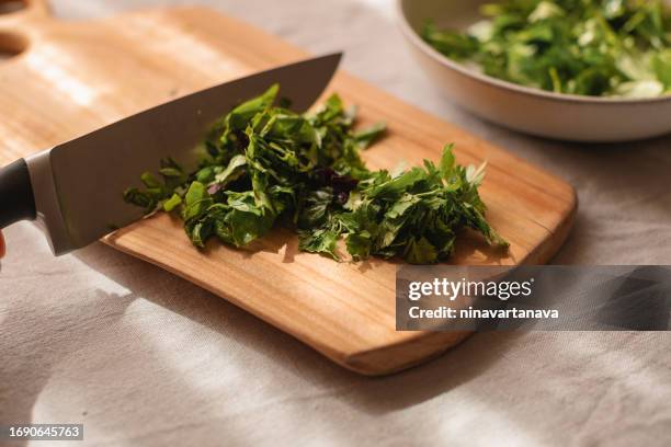 close-up of coriander being chopped on a chopping board - chopping cilantro stock pictures, royalty-free photos & images