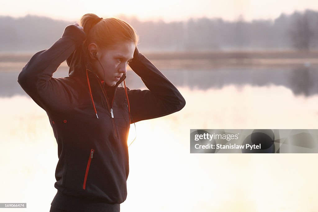 Girl preparing to jogging at morning near a lake