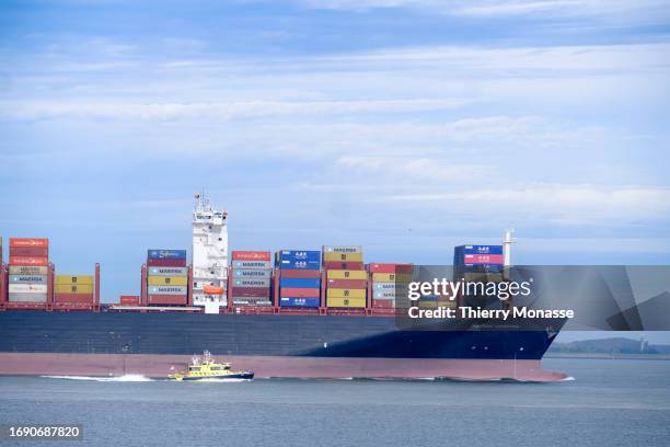 The Dutch Patrol Vessel RWS 79 and the countainer ship, sailing the flag of United Kingdom Maersk Campton goes upstream at the mouth of the Scheldt...