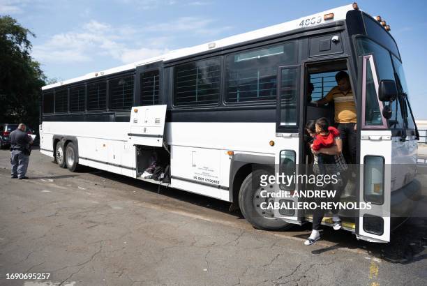 Migrants recently processed by the US Customs and Border Patrol get off a bus at a transposition assistance center in Eagle Pass, Texas on September...