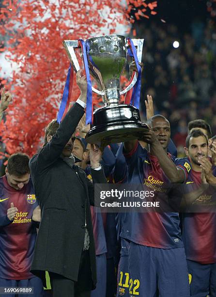 Barcelona's coach Tito Vilanova and Barcelona's French defender Eric Abidal hold the trophy during a ceremony at the Camp Nou stadium in Barcelona on...