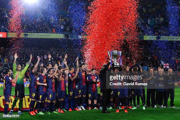 Head coach Tito Vilanova and Eric Abidal of FC Barcelona holds up the trophy during the celebration after winning the Spanish League after the La...