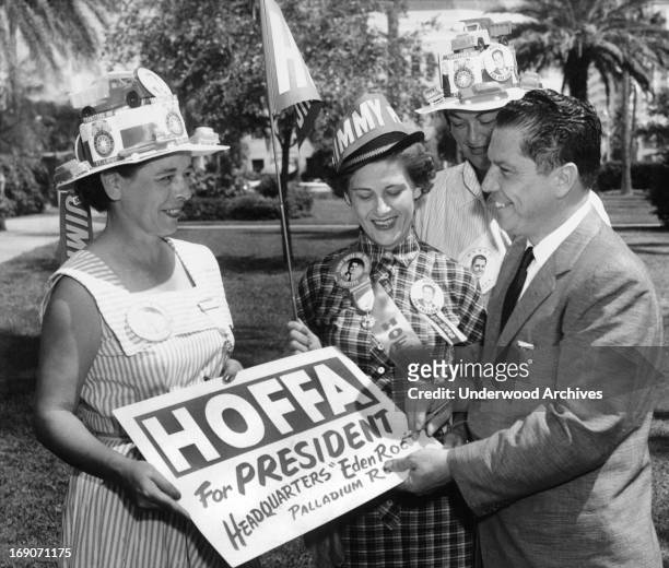 Teamsters union vice president JImmy Hoffa autographs a placard for him for a group of women campaigning for his run for president of the Teamsters,...