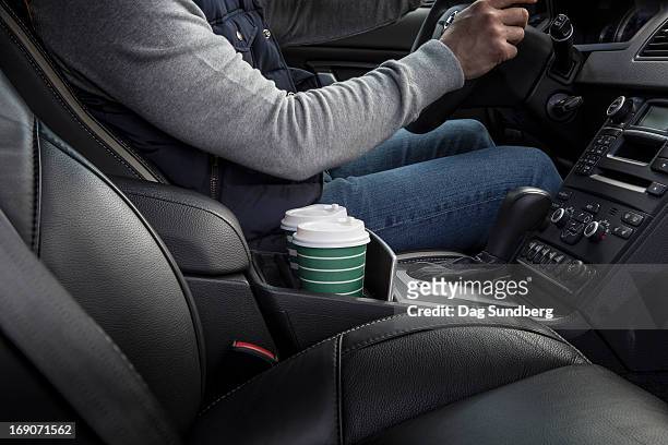 driver with cups in a car holder - voertuiginterieur stockfoto's en -beelden