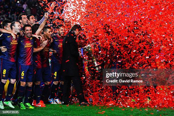 Head coach Tito Vilanova holds the trophy as his players celebrate during the celebration after winning the Spanish League after the La Liga match...