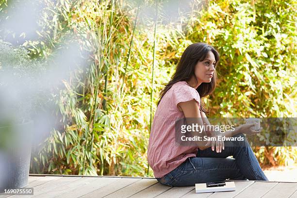 woman drinking coffee on patio - coffee on patio stock pictures, royalty-free photos & images