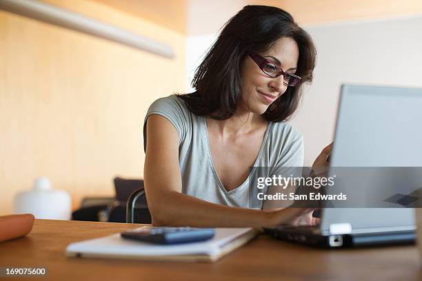 woman using laptop and cell phone - answering email stock pictures, royalty-free photos & images