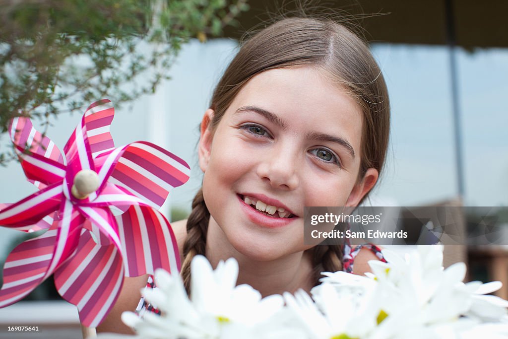 Sonriente niña sosteniendo UN MOLINETE al aire libre