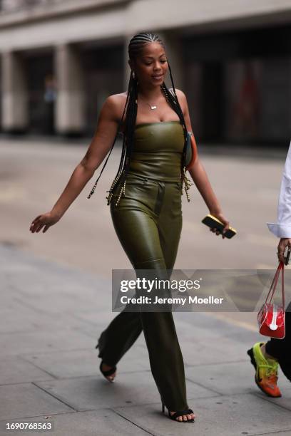 Joelah Noble was seen wearing a orange and green bag, a olive green strapless top and also olive green pants during London Fashion Week September...