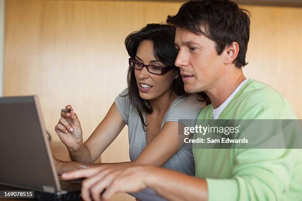 couple paying bills on laptop together - digital business relationship stock pictures, royalty-free photos & images