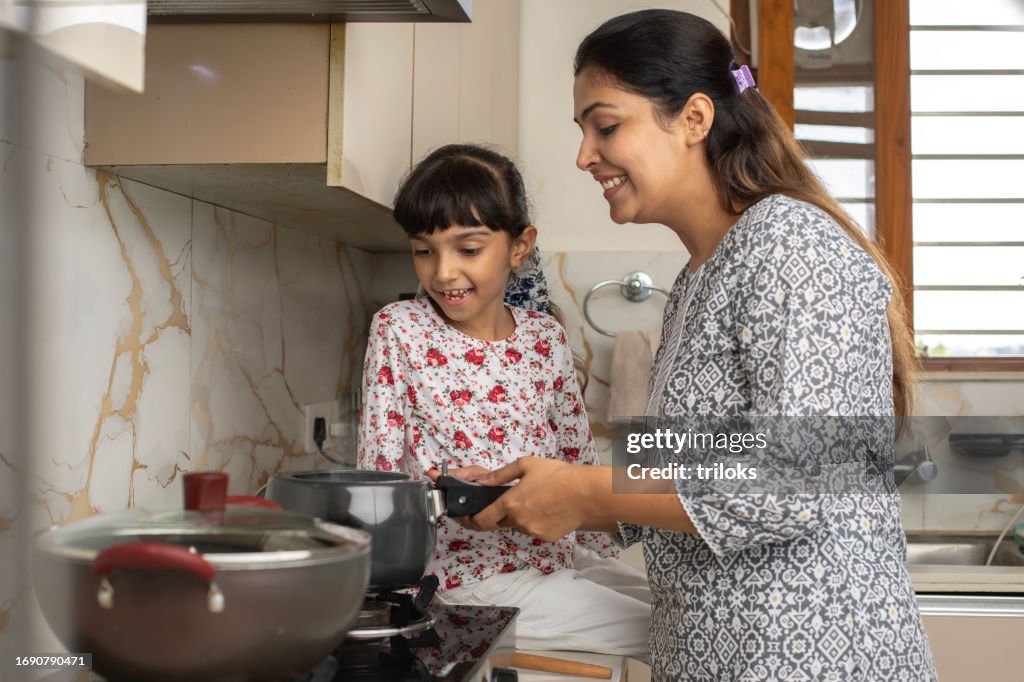 Mother and daughter cooking together in kitchen