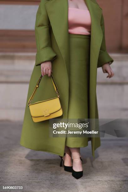 Nicola Coughla was seen wearing black shoes, a long green skirt, a rose strapless top, a yellow bag and a matching green coat before Emilia Wickstead...