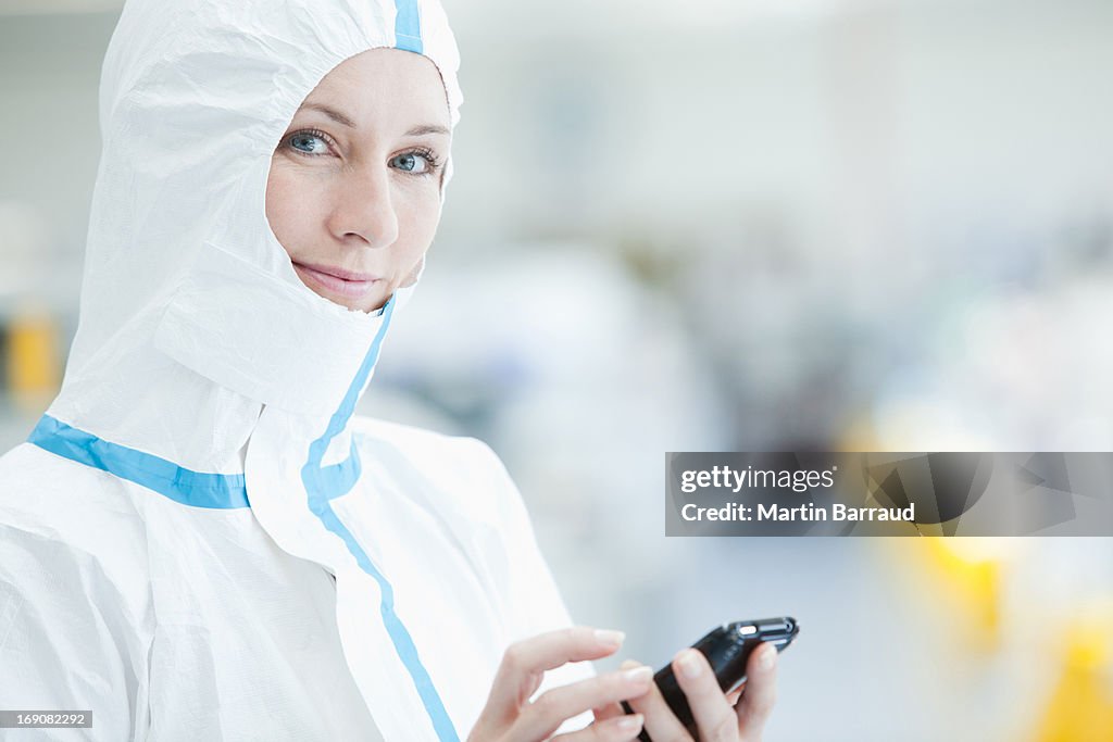 Scientist in protective gear using cell phone