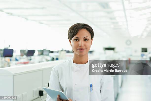 scientist holding tablet computer in lab - black woman in lab stock pictures, royalty-free photos & images