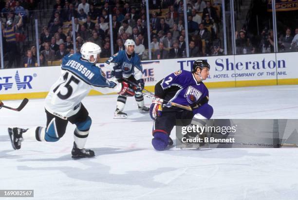 Daniel Alfredsson of the Eastern Conference and the Ottawa Senators shoots as Al MacInnis of the Western Conference and the St. Louis Blues tries to...