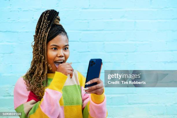 woman reacting to smart phone - excitação imagens e fotografias de stock