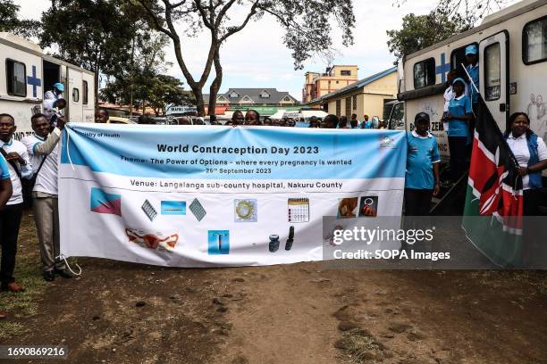 People march while holding a banner during the national celebrations of The World Contraception Day. According to data from Kenya Demographic and...