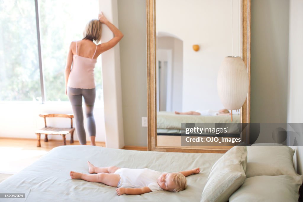 Mother and baby relaxing on bed