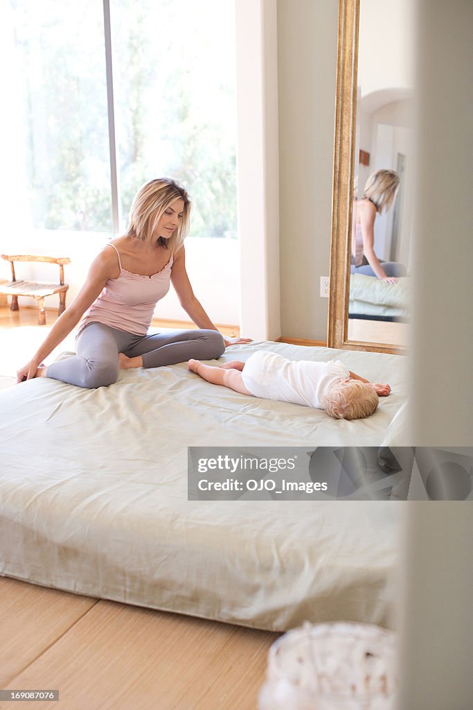 Mãe e bebé relaxante na cama