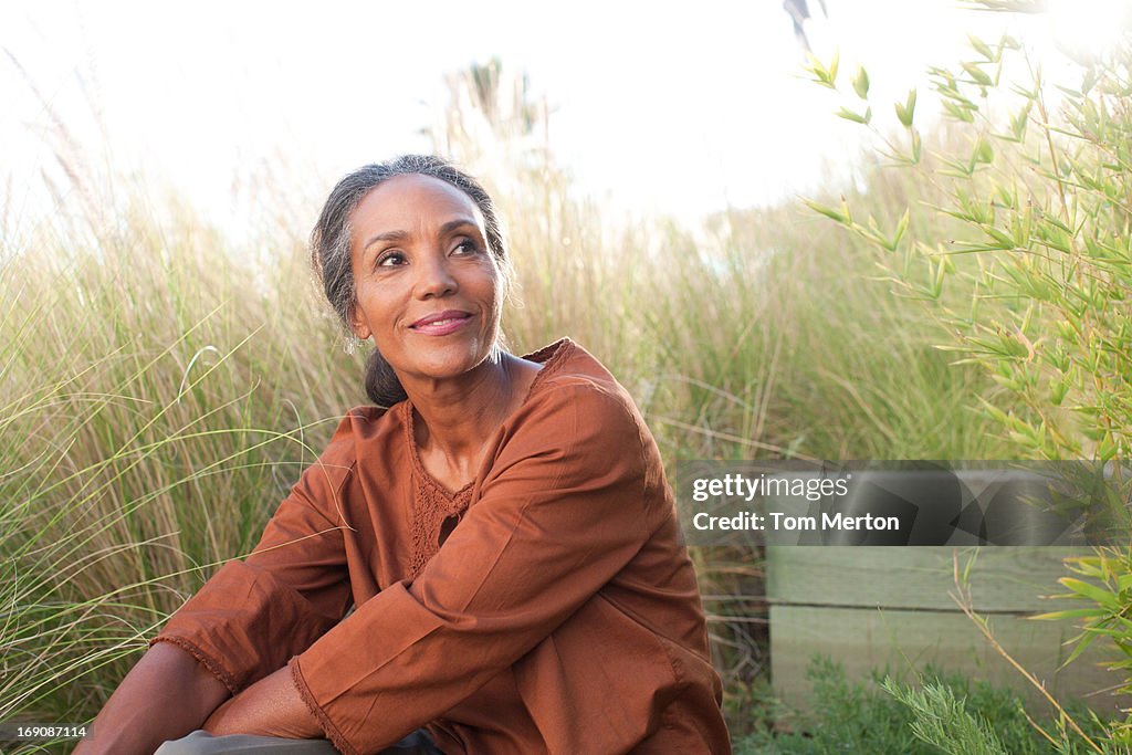 Ruhige Frau sitzt in einem sonnigen Feld