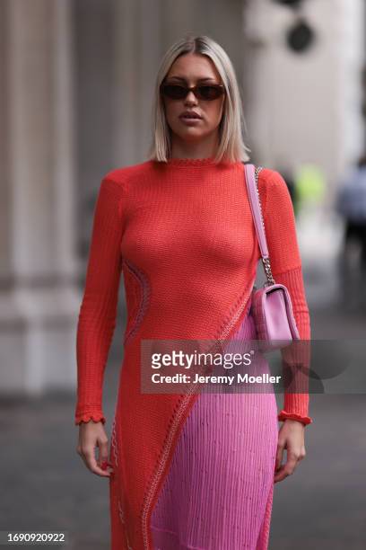 Fashion week guest was seen wearing brown shades, a pink Burberry bag and a red and rose colored dress before Emilia Wickstead Fashion Show during...