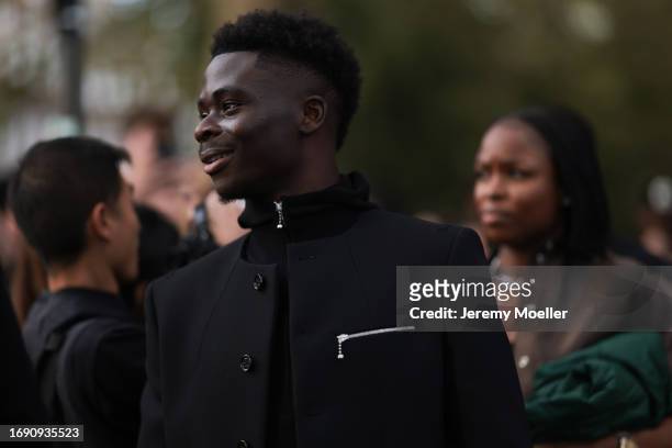 Bukayo Saka was seen wearing a black jacket under a black blater with black buttons and silver zipper during London Fashion Week September 2023 at...