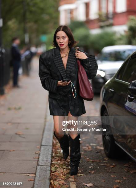 Tiffany Hsu was seen wearing black leather heels, lots of yellow gold jewelry including a Tiffany chain, earrings and rings, an oversized black and...