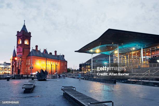 the redeveloped cardiff docks illuminated at dusk - parliament building stock pictures, royalty-free photos & images