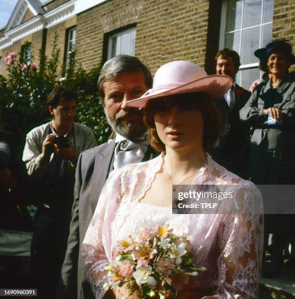 Portrait of couple actor Oliver Reed and Josephine Burge at their wedding, Surrey, England, July 9, 1985.