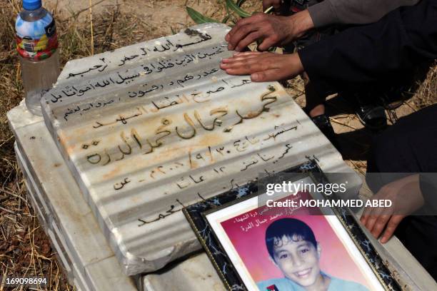 Jamal al-Dura and his family, visit the grave of their son Mohammed, at the Bureij cemetery in the central of Gaza Strip, on May 20, 2013. Mohammed...