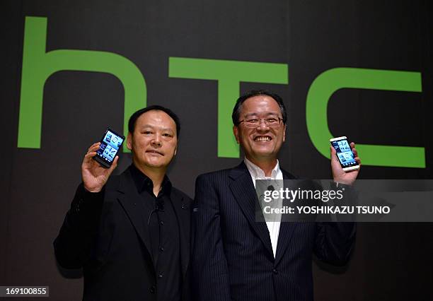 Taiwan's HTC CEO Peter Chou and Japan's KDDI president Takashi Tanaka display the new smartphone "HTC J One" at a launch event in Tokyo on May 20,...