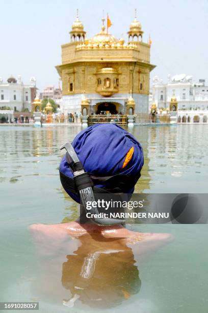 An Indian Sikh takes a ritual bath in the water tank of the Golden Temple in Amritsar on May 2, 2008 on the occasion of the 445th birth anniversary...