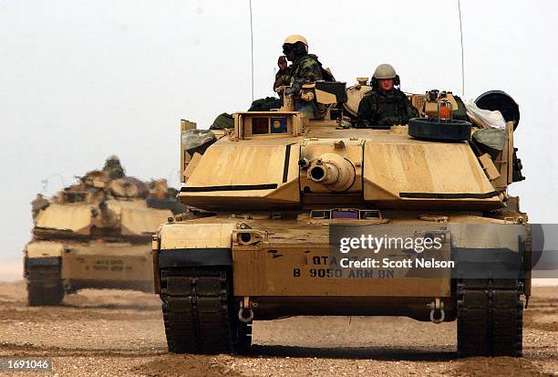 Abrams tanks from the Charlie company 464 Armored Battalion depart for task force manuevers December 17, 2002 near the Iraqi border in the Kuwaiti...