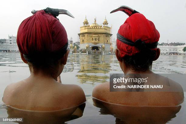 Indian Sikh devotees take a dip in the holy sarover of the Golden temple on the occasion of Bandi Chhor Divas in Amritsar, 21 October 2006....