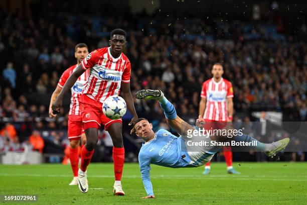 Phil Foden of Manchester City attempts an acrobatic shot whilst under pressure from Nasser Djiga of FK Crvena zvezda during the UEFA Champions League...