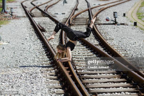 urban dancer on railroad tracks - weird performance art stock pictures, royalty-free photos & images