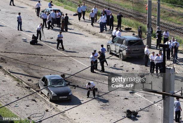 Police investigators work at a blast site outside a building used by court bailiffs in central Makhachkala on May 20, 2013. At least eight people...