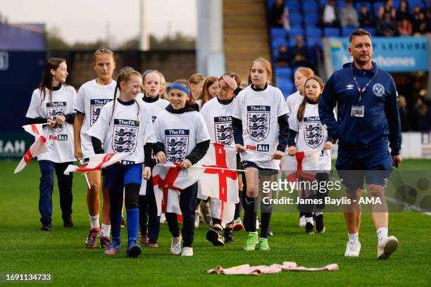 Young England mascots with England flags before the Women's International Friendly between England Women U23 and Belgium U23 at The Croud Meadow on...