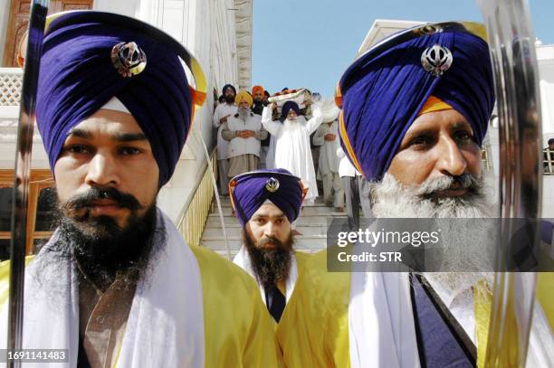 Indian Sikh devotees walk ahead of the Guru Granth Sahib, the holy book of the Sikh religion, in a procession at the Golden Temple in Amritsar, 14...