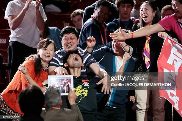 China's Zhang Jike celebrates with people in the stands, on May 20, 2013 in Paris, after his victory over China's Wang Hao in the Final of the Men's...