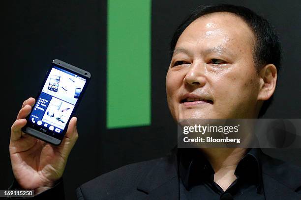 Peter Chou, chief executive officer of HTC Corp., holds the HTC J One HTL22 smartphone during the unveiling event in Tokyo, Japan, on Monday, May 20,...