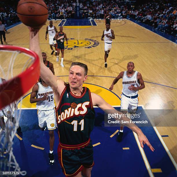 Detlef Schrempf of the Seattle Supersonics dunks against the Golden State Warriors circa 1996 at the Oakland-Alameda County Coliseum Arena in...