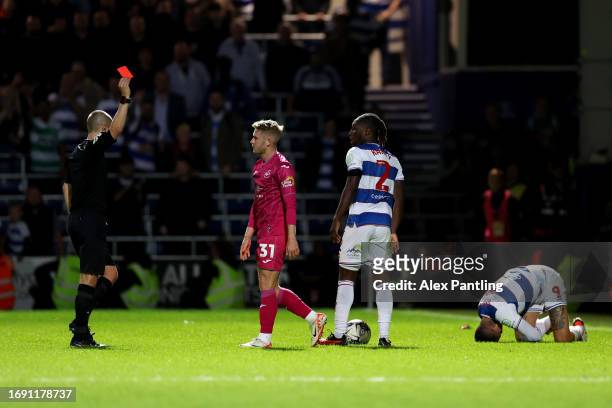 Ollie Cooper of Swansea City is shown a red card by referee Andrew Kitchen during the Sky Bet Championship match between Queens Park Rangers and...