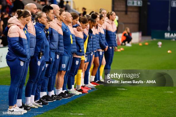 England management staff and coaches observe a minute of silence in tribute to Maddy Cusack during the Women's International Friendly between England...