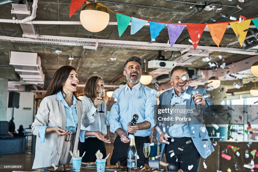 Business people celebrating with party popper in office