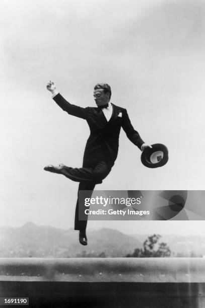 American actor James Cagney , wearing a tuxedo, holds his hat in one hand as he leaps high into the air outdoors, 1930s. Cagney won an Academy Award...