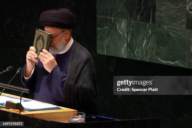 Iran's President Ebrahim Raisi holds the Koran as he address world leaders during the United Nations General Assembly on September 19, 2023 in New...