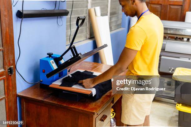 adult man working on a iron sublimation. printing and graphic design concept. - graphic print fabric stock pictures, royalty-free photos & images
